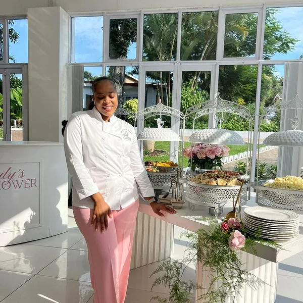 MaShandu in her chef's whites at a pink and white baby shower buffet